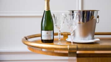 A bottle of champagne, two glasses, and a silver bucket on a wooden tray.