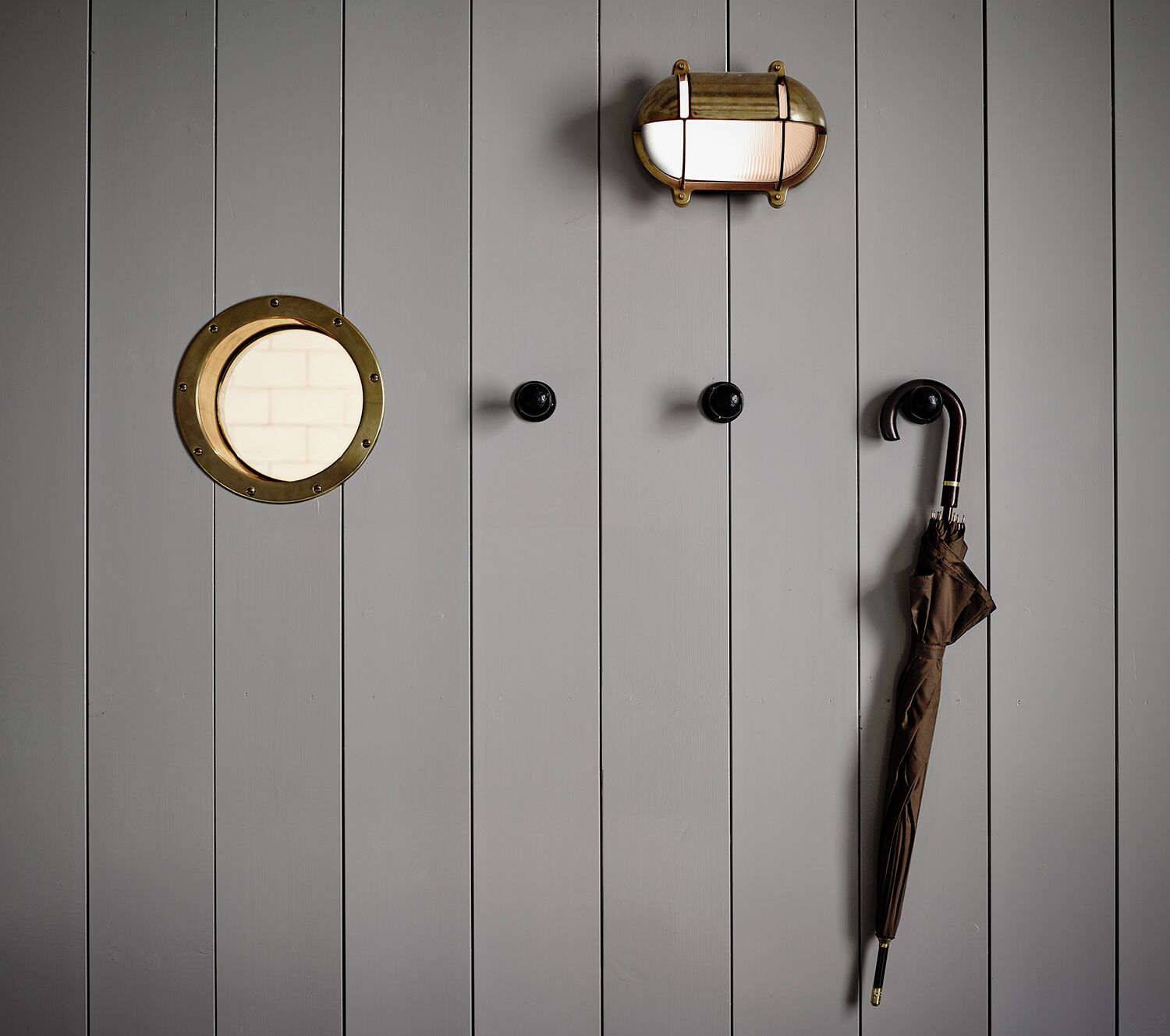 A door with a round mirror, a light fixture, and a door handle.