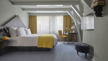 Ein Hotelzimmer mit Bett, Schreibtisch, Stuhl und einem kleinen Hocker.
