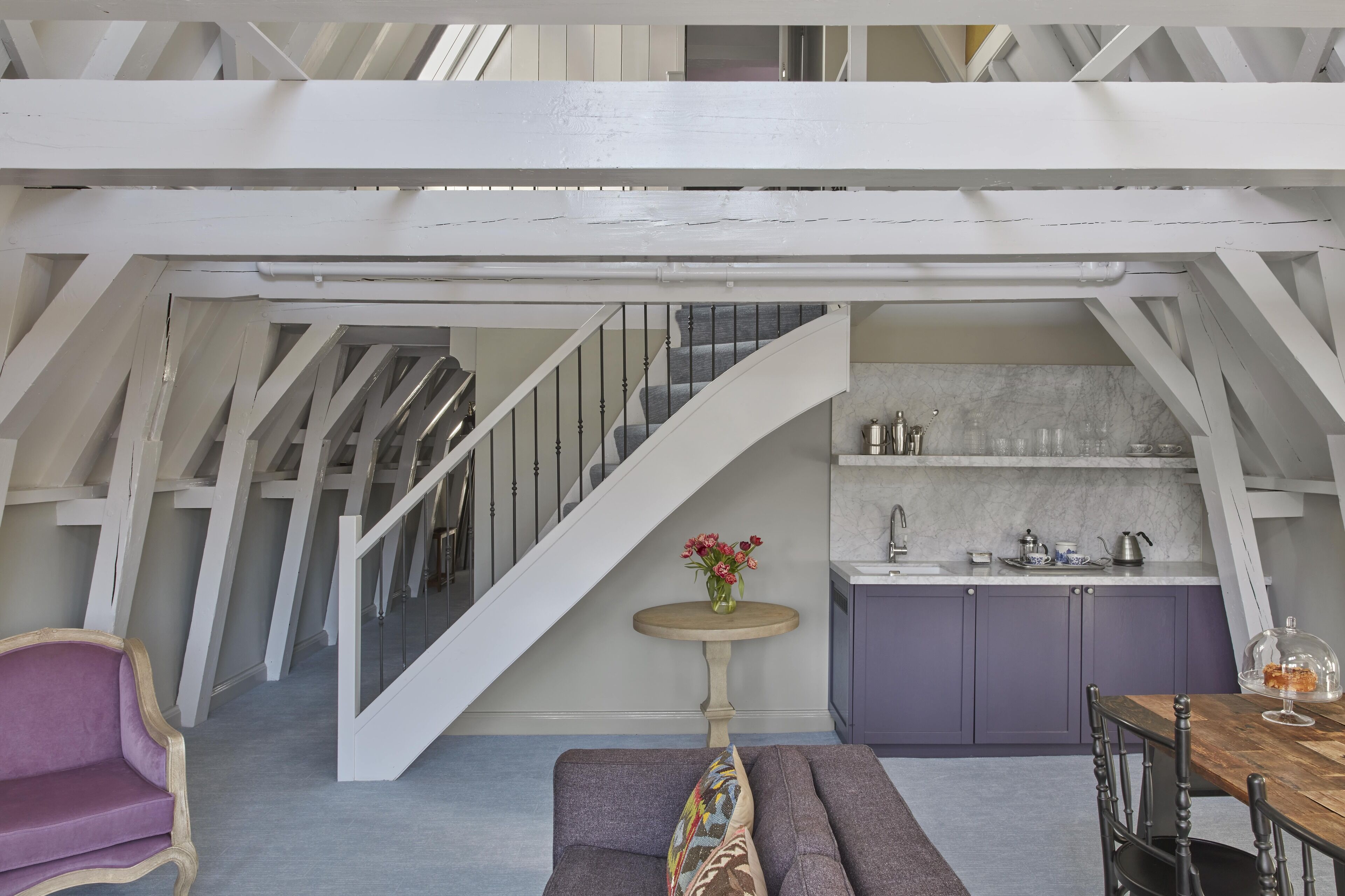 A loft-style room with a staircase, a dining area, and a kitchen.
