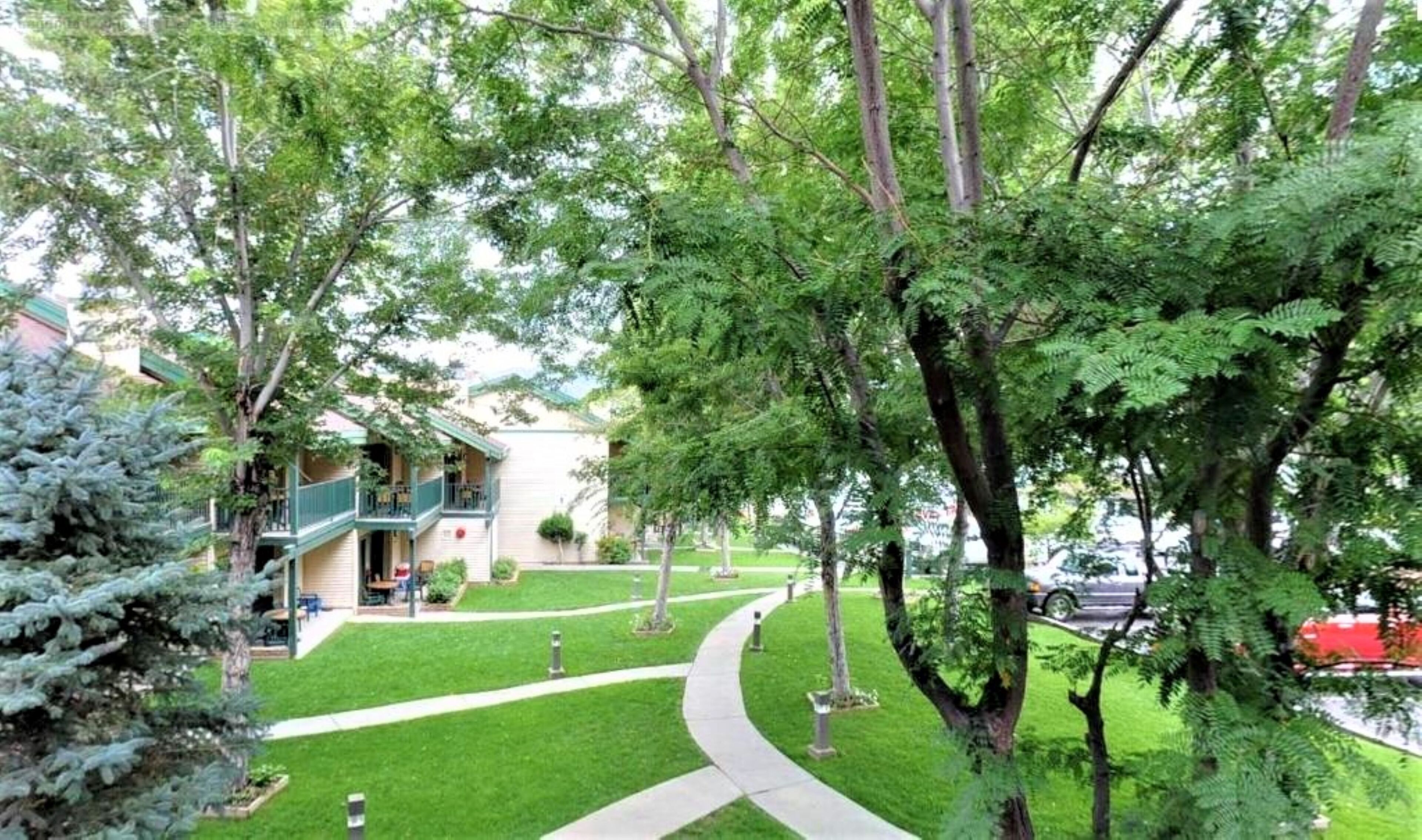 A residential area with a pathway leading to a building with a balcony.