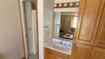 A bathroom with a wooden vanity, a sink, and a mirror.