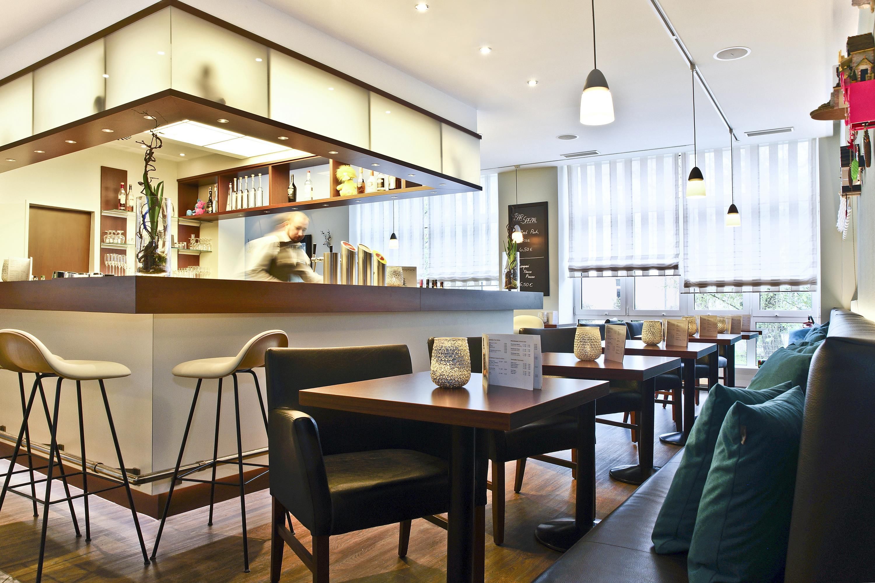 A modern restaurant interior with a bar area, seating arrangements, and a menu board.