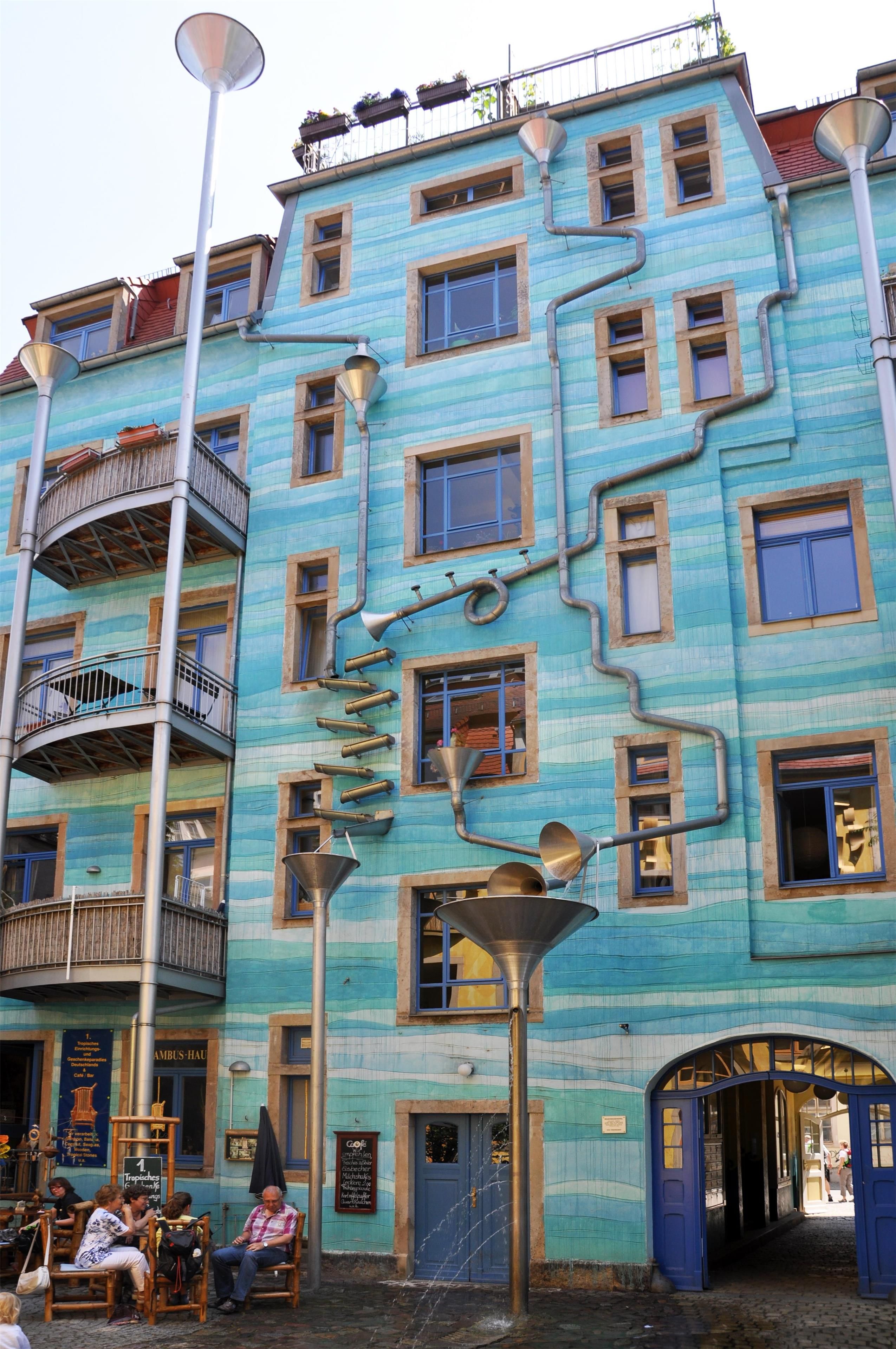 Een meerlaags gebouw met een opvallend architectonisch ontwerp, met een combinatie van balkons en ramen.