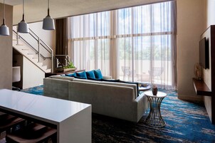 Una sala de estar moderna con un sofá, una mesa de comedor y una escalera.
