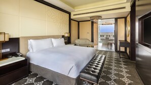 A hotel room with a large bed, a bedside table with a lamp, a chair, a small table, and a TV. - InterContinental Dhaka by IHG (Dhaka)