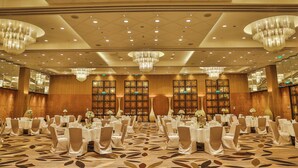 A banquet hall with round tables, chandeliers, and mirrored walls. - InterContinental Dhaka by IHG (Dhaka)