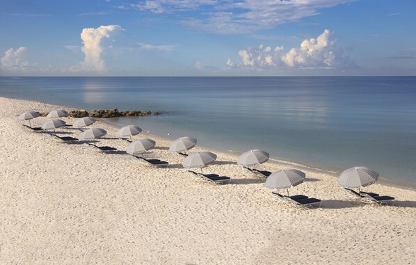 Plage privée, sable blanc, chaises longues, parasols