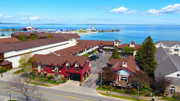 A coastal town with a marina, red-roofed buildings, and a clear view of the sea. - Super 8 by Wyndham Mackinaw City/Beachfront Area (Mackinaw City)