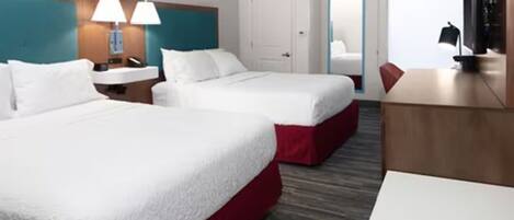 Une chambre d’hôtel avec deux lits, un bureau, une chaise, une télévision et une salle de bain.