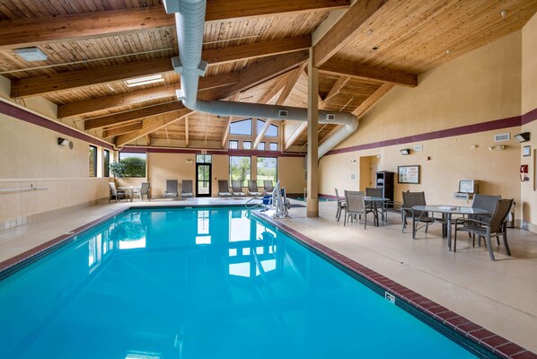 Una piscina techada, sillones reclinables de piscina