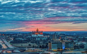 A cityscape with a prominent building with a golden dome, surrounded by modern buildings and a highway. - Holiday Inn Downtown - Mercy Area by IHG (Des Moines)