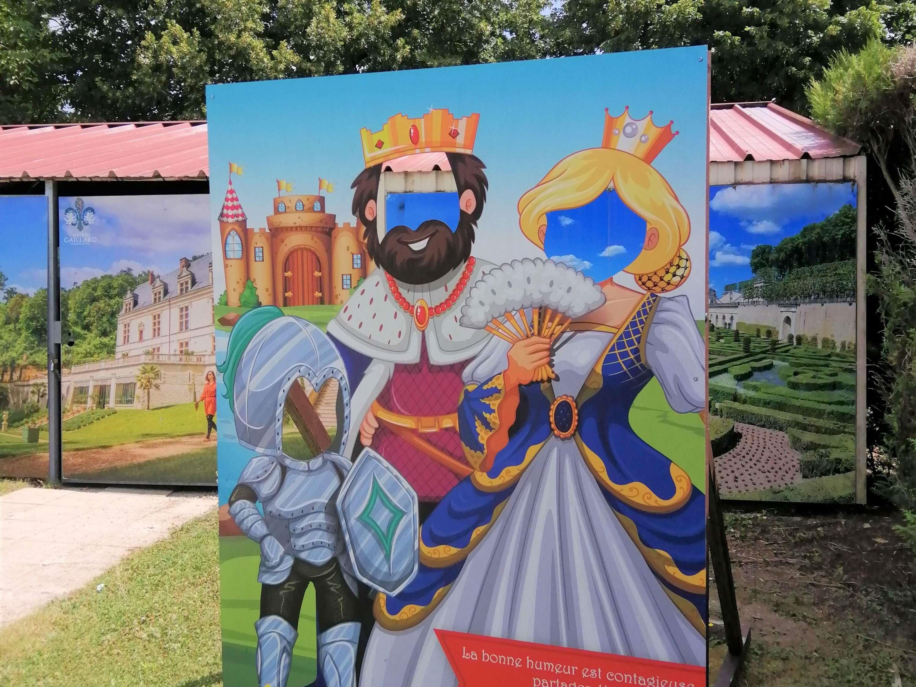 A poster with a man and a woman in medieval attire, a castle, and a garden.