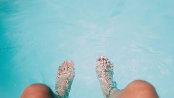 A pair of feet in a clear blue pool.