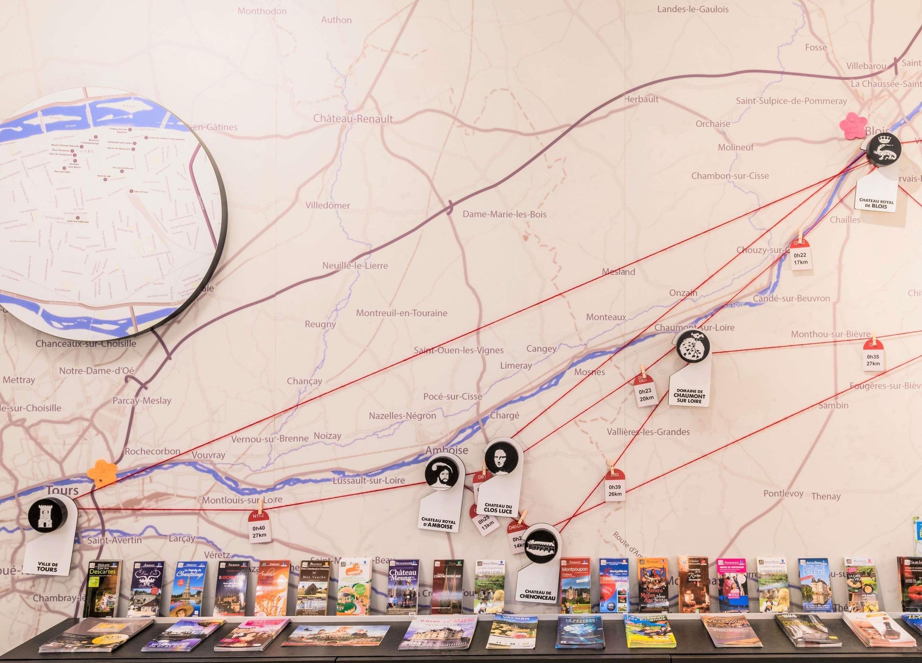 Un mapa con ubicaciones marcadas y una fila de libros de viajes.