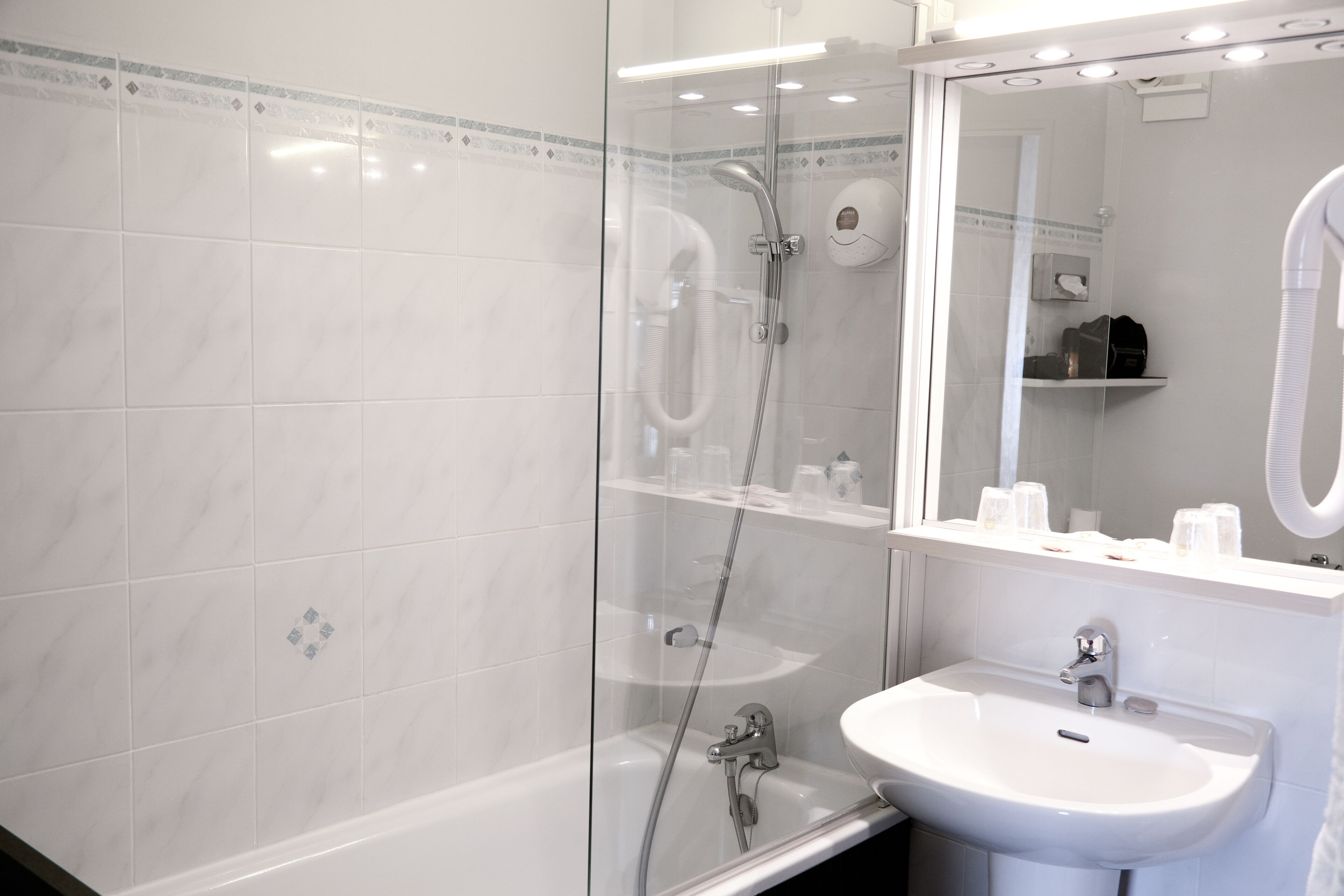 A modern bathroom with a glass-enclosed shower, a white sink, and a mirror above the sink.
