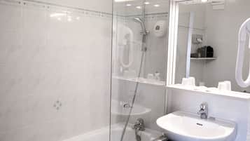 A modern bathroom with a glass-enclosed shower, a white sink, and a mirror above the sink.