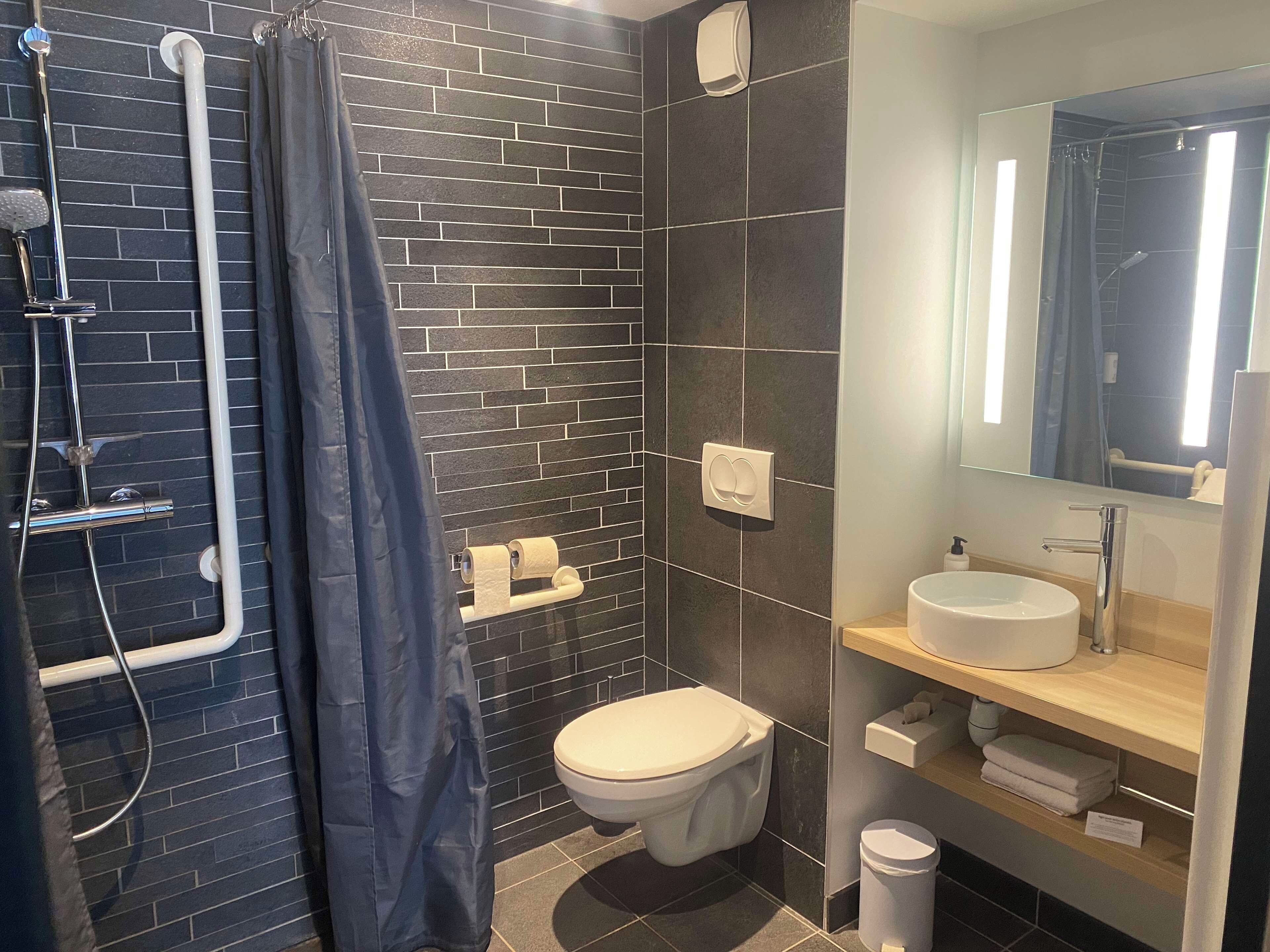 Un baño moderno con ducha, inodoro y lavamanos.