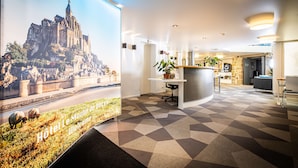 A hotel lobby with a large poster of a castle, a reception desk, and a modern interior design. - Best Western Le Moulin De Ducey (Ducey-les-Chéris)