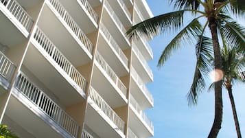 A multi-story hotel with balconies and palm trees.