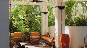An indoor garden with seating, a large vase, and a ceiling fan.