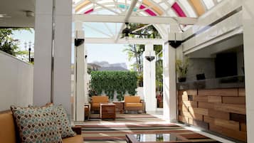 A modern interior with a glass ceiling, a seating area with sofas, a wooden wall, and a fireplace.