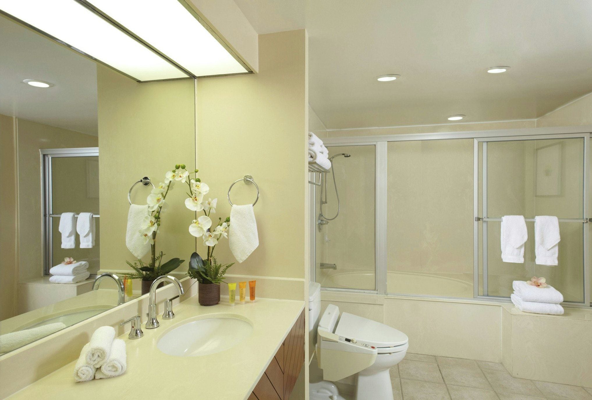 A modern bathroom with a sink, mirror, and shower area.