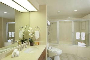 A modern bathroom with a sink, mirror, and shower area.