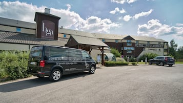 Un hotel con un cartel que dice "HOTEL RESTAURANT" y una furgoneta estacionada adelante.