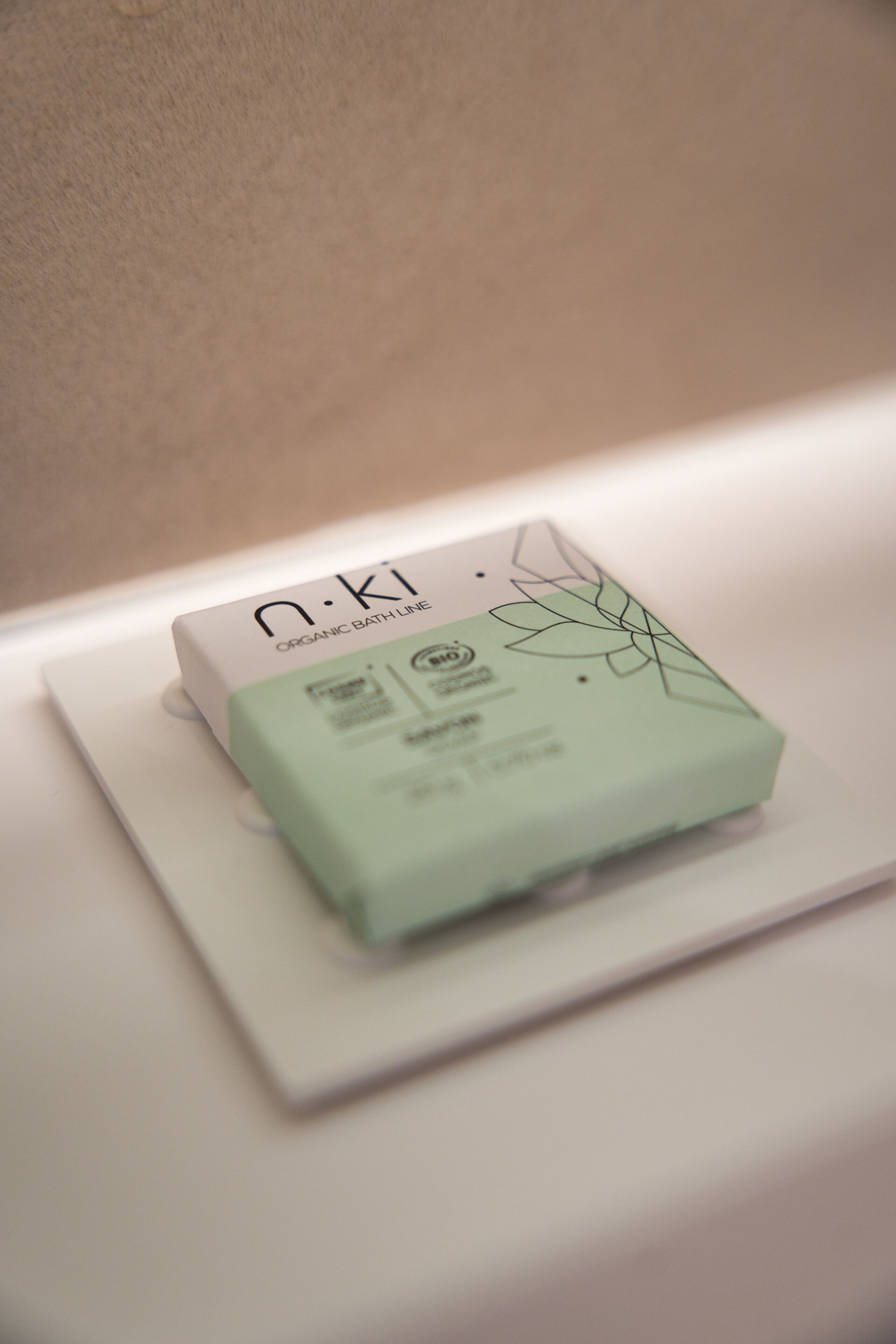 Un emballage portant la mention « n.ki, gamme de produits de bain biologiques », posé sur une surface blanche.