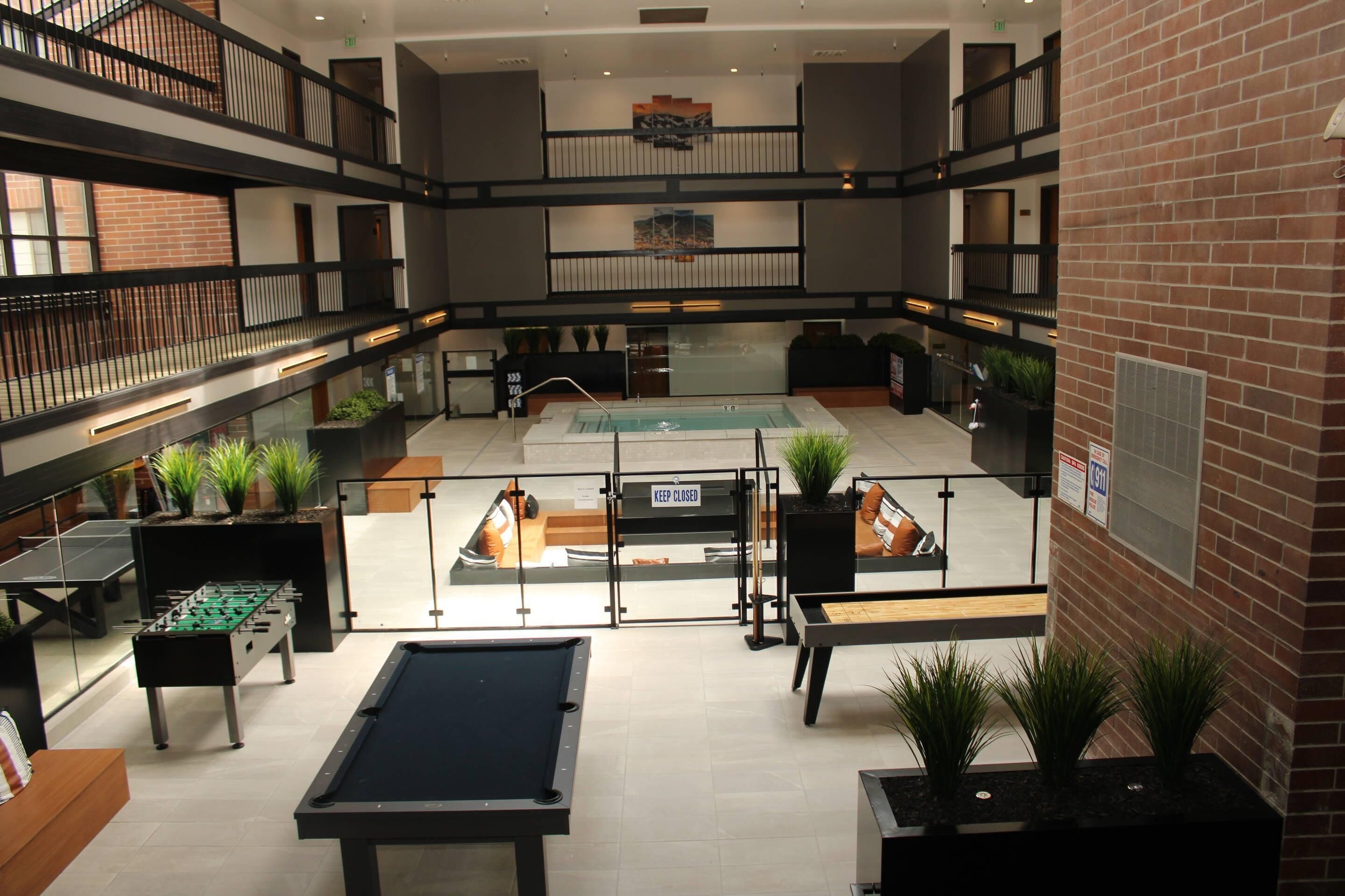 A multi-level indoor recreational area with a pool table, foosball table, and ping pong table.