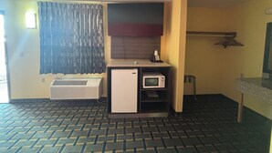 A compact kitchenette with a refrigerator, microwave, and a small countertop. - Villa Inn (Lawrenceburg)