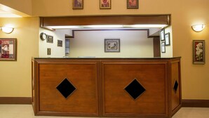 Una recepción con detalles de madera, cuadros en la pared y una lámpara colgante.