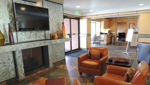 A lobby with leather sofas, a flat-screen TV, and a fireplace. - Park Regency Resort (Park City)