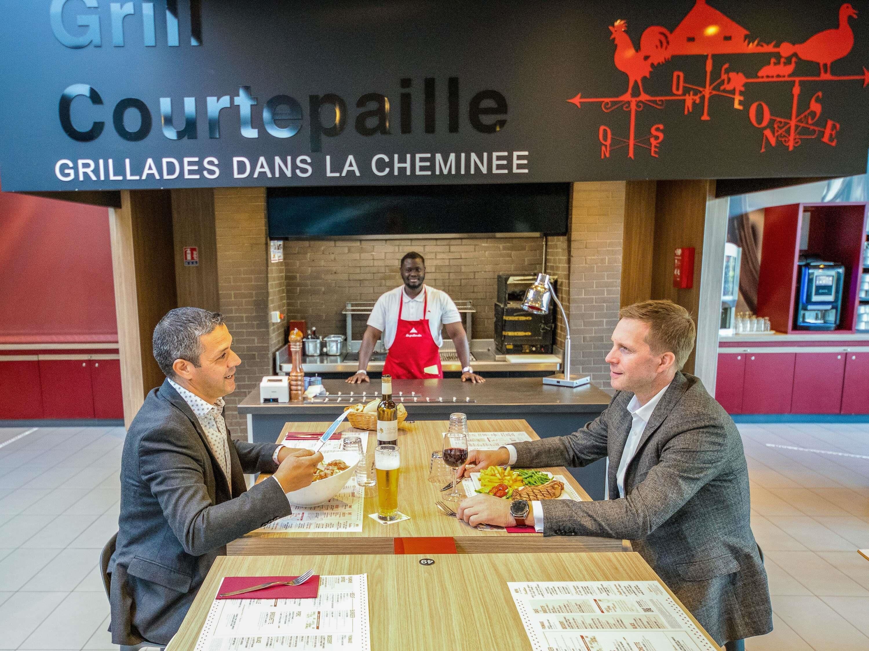 Un restaurant avec une enseigne indiquant : « Grill Courtepaille, grillades au feu de bois ».
