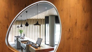 Een moderne kantoorruimte met een gebogen spiegel die het interieur weerspiegelt.