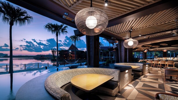 A modern outdoor seating area with a view of the water, featuring geometric patterned flooring and contemporary lighting fixtures. - Disney's Polynesian Village Resort (Lake Buena Vista)