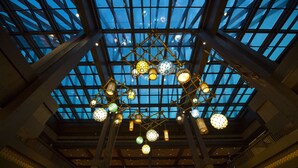 A spacious atrium with a high ceiling and a glass roof, featuring multiple levels and a central chandelier. - Disney's Polynesian Village Resort (Lake Buena Vista)