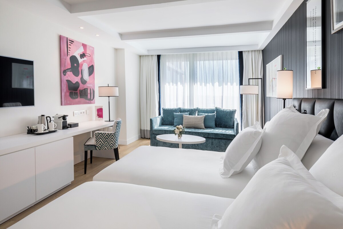 Een moderne hotelkamer met een groot bed, een bureau, een bank en een televisie.