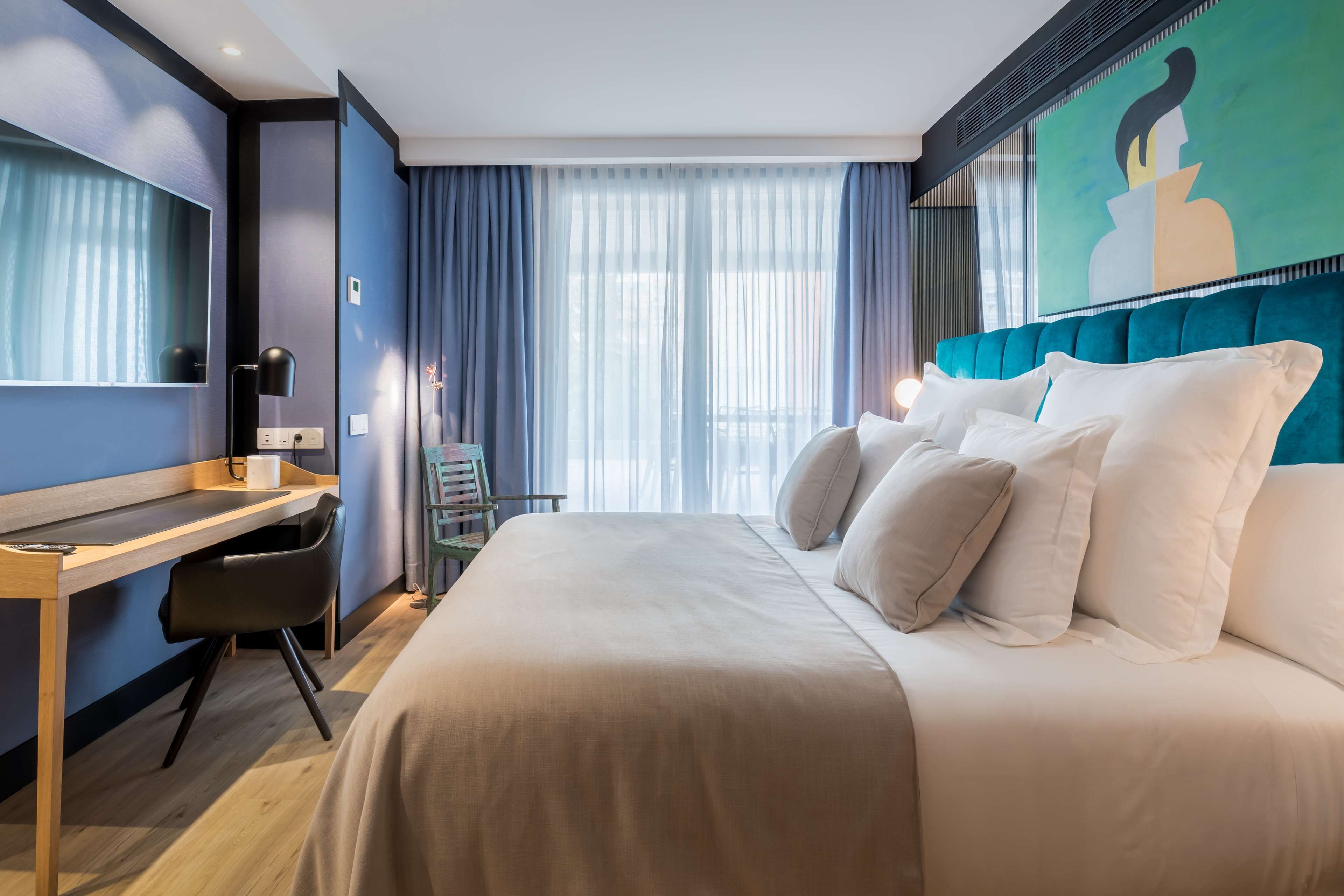 Una habitación de hotel moderna con una cama grande, un escritorio y una silla.