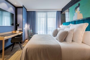 Una habitación de hotel moderna con una cama grande, un escritorio y una silla.