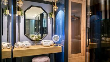 A bathroom vanity with a mirror, towel, and a round light.