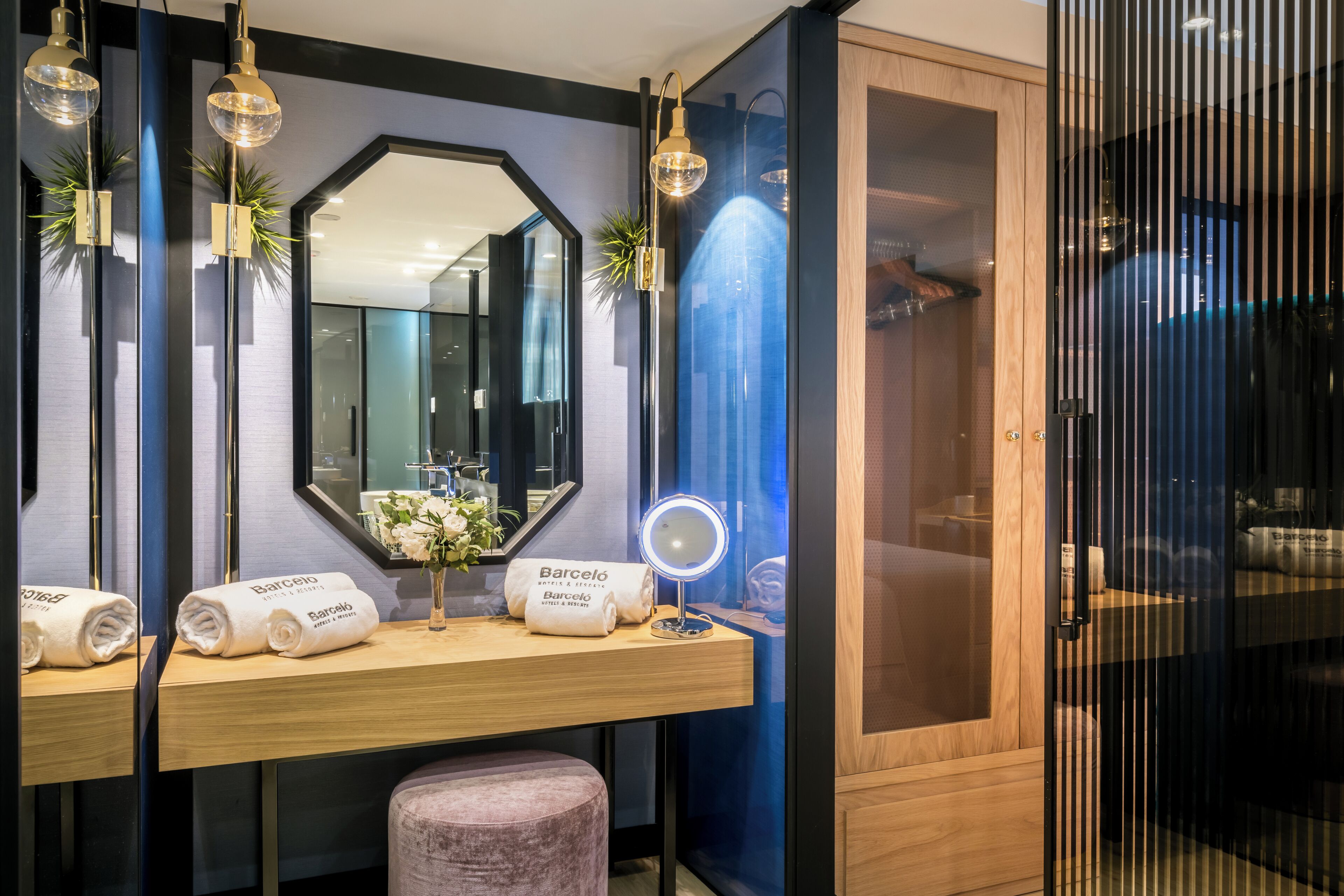 A bathroom with a vanity, a mirror, and a towel rack with towels.