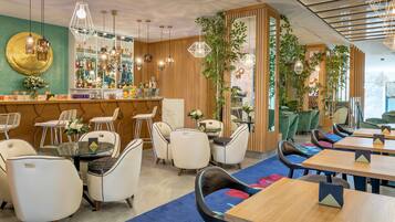 Ein modernes Restaurant mit Barbereich, Sitzgelegenheiten und dekorativen Pflanzen.