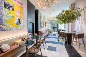 A modern interior with a seating area, a dining table, and a large decorative map on the wall.