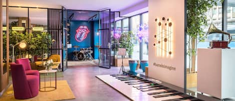 A modern interior with a piano keyboard display, a neon sign, and a plant.