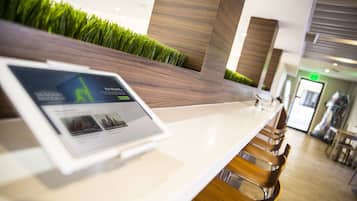 A reception area with a digital screen displaying content, a reception desk, and a seating area with chairs.