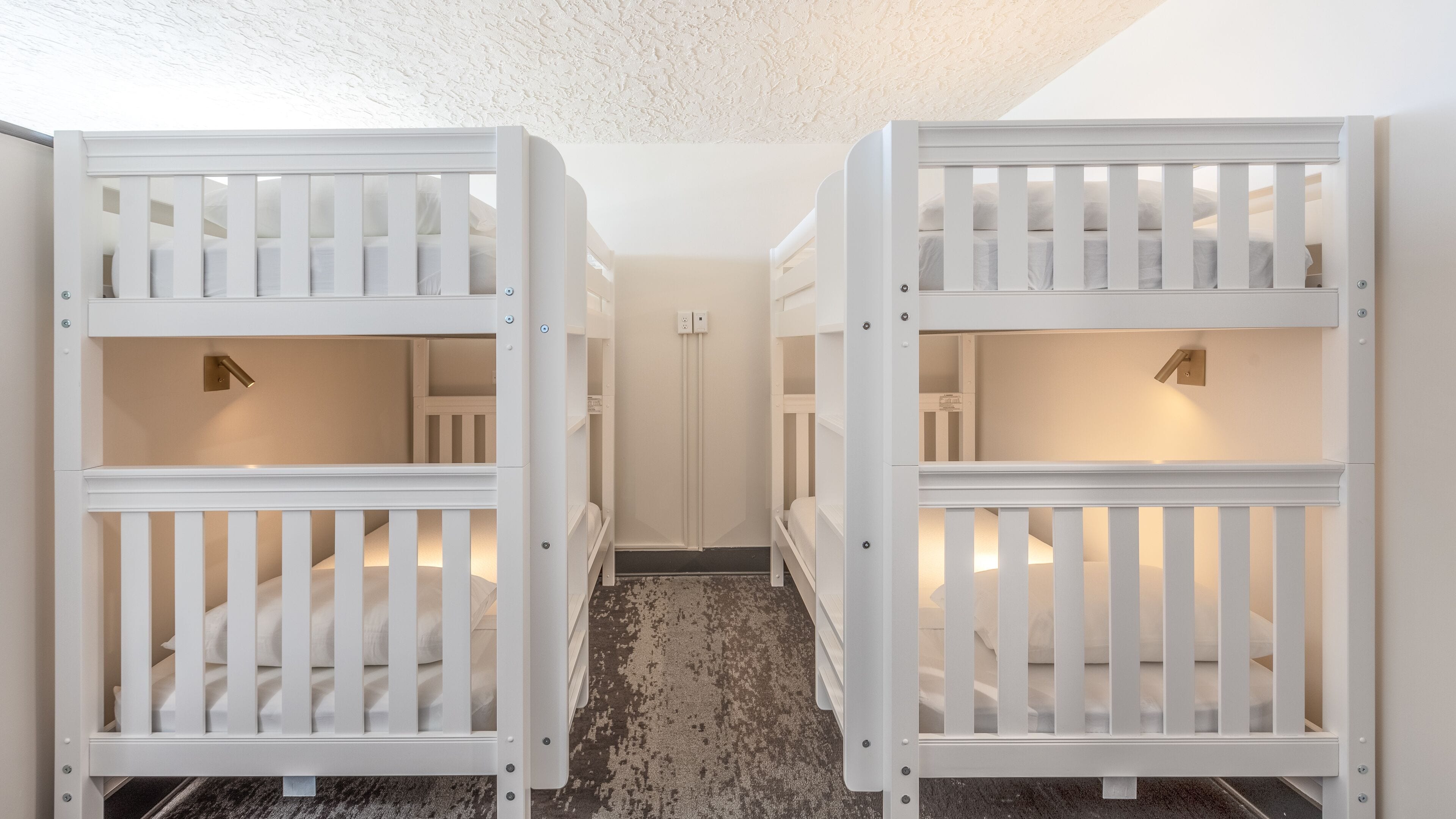 A hallway with bunk beds, a door, and a carpeted floor.
