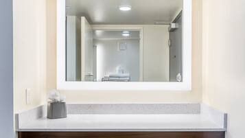 A bathroom with a mirror, a towel rack, and a tissue box on the counter.