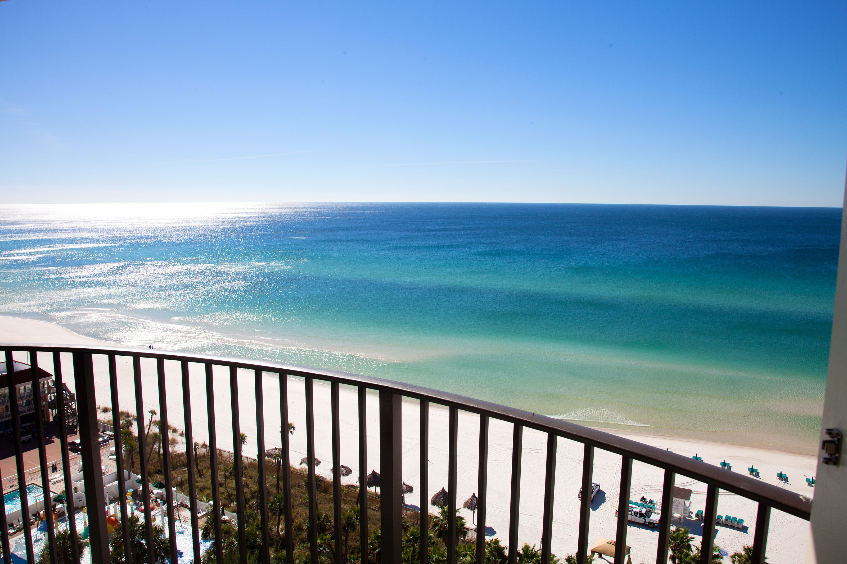 A balcony with a view of a beach and ocean.